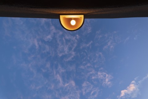 Low angle view of outdoor lamp on building against blue sky