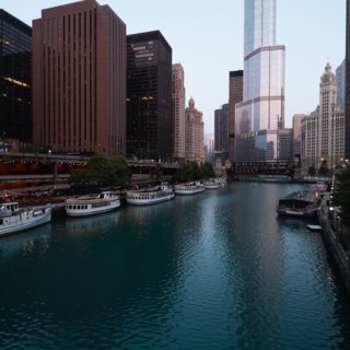 Usa, Illinois, Chicago, Downtown buildings and boats moored by river at dawn