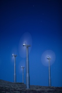 Wind turbines in landscape at night