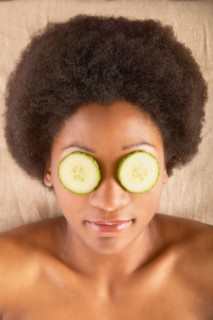 Woman with cucumber slices over eyes