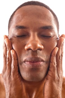 Close-up of man rubbing face