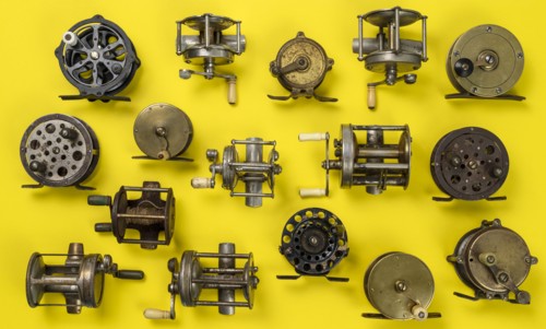 Vintage fishing reels on yellow background