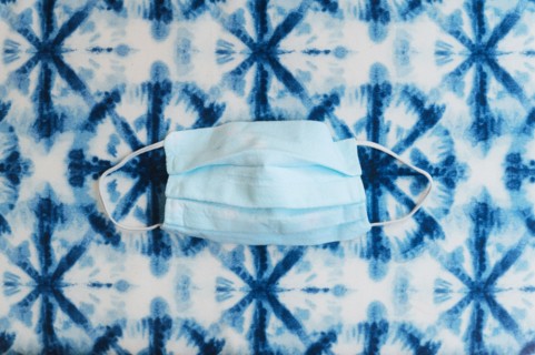 Face mask on patterned blue background