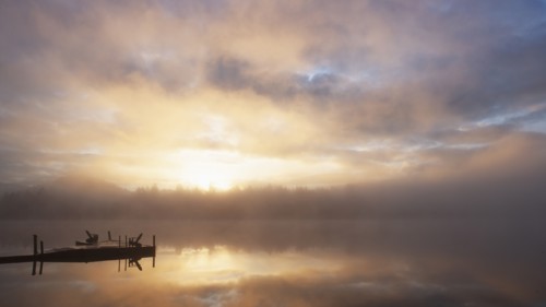 Lake Placid reflecting sunlight and clouds at sunrise