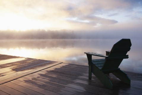 Adirondack chair on pier at sunrise