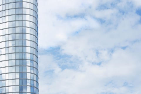 Tall modern building exterior and cloud covered sky