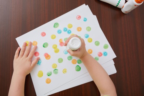 Overhead view of hands of girl painting