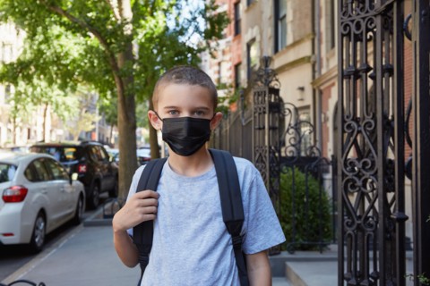 Portrait of Boy in face mask standing on sidewalk