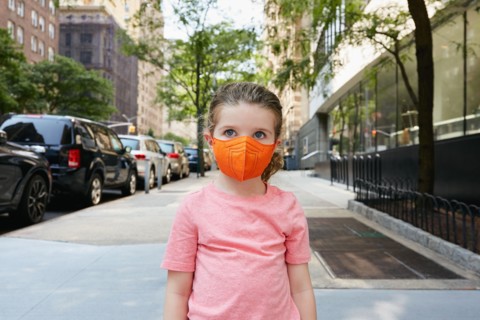 Portrait of girl in face mask standing on sidewalk
