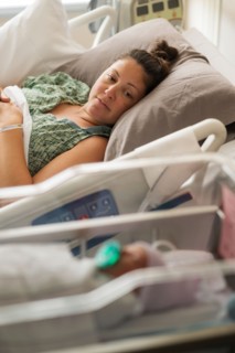 Mother lying with newborn baby girl