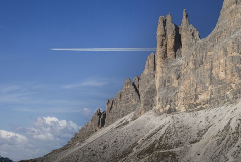 Commercial jet flying over Dolomites
