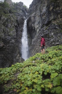 Hiker standing near waterfall