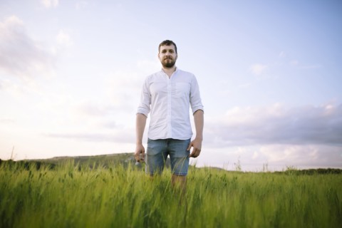 Mid adult man standing in agricultural field