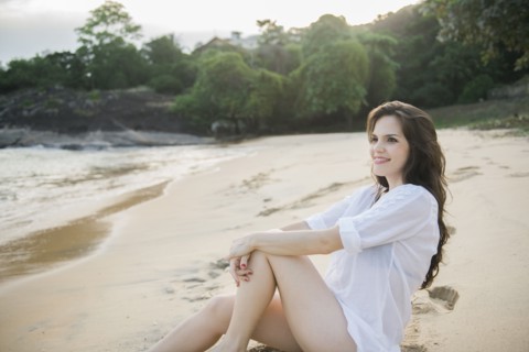 Smiling Caucasian woman sitting on beach