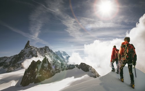 Caucasian hikers standing on snowy mountain top