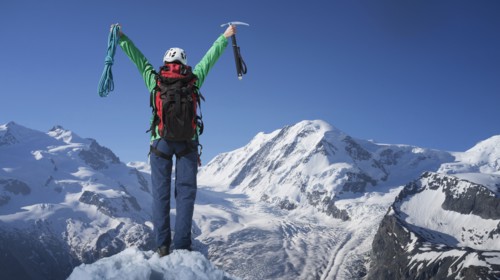 Caucasian hiker cheering on mountaintop
