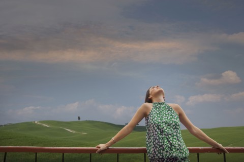 Caucasian woman admiring blue sky in rolling landscape