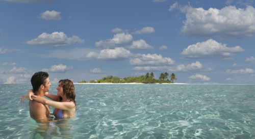 Caucasian couple hugging in tropical ocean