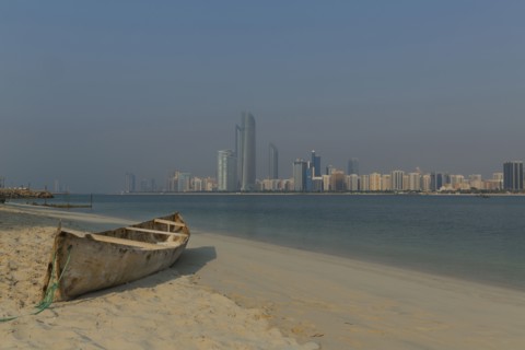 Canoe on beach near city skyline