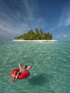 Caucasian man floating near tropical island