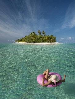 Caucasian woman floating near tropical island