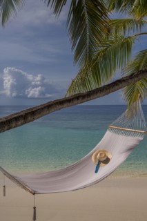 Sun hat in empty hammock on beach