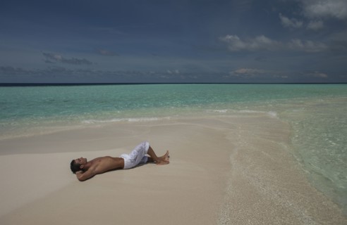 Caucasian man laying on beach
