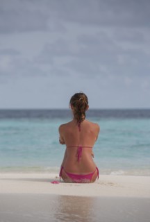 Caucasian woman sitting on beach