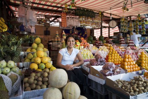 Asian vendor smiling at market