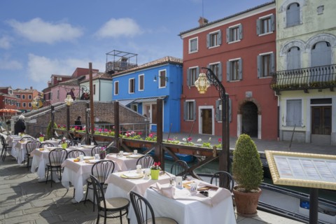 Sidewalk cafe overlooking Venice Burano canal