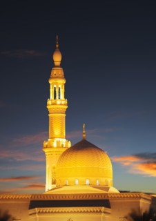Illuminated pillar and dome under sunset sky