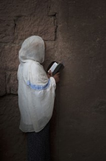 Black woman reading at wall