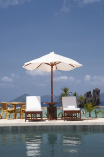 Lawn chair and umbrella at swimming pool