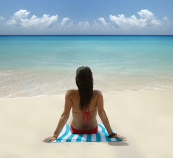 Caucasian woman laying on tropical beach
