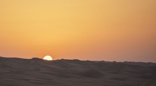 Sunrise over sand dunes in desert landscape