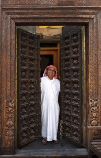 Smiling man opening ornate doors