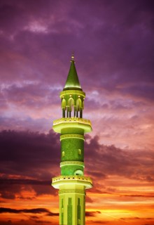 Illuminated tower against sunset sky