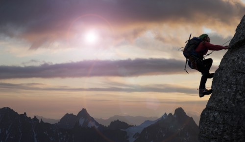Caucasian climber scaling mountain in remote landscape