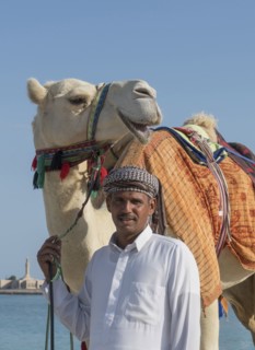 Middle Eastern man with camel near city
