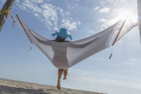 Caucasian woman in hammock at beach