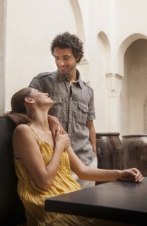 Smiling Caucasian couple holding hands at table outdoors
