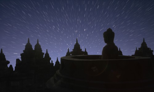 Silhouette of statue of Buddha at sunset