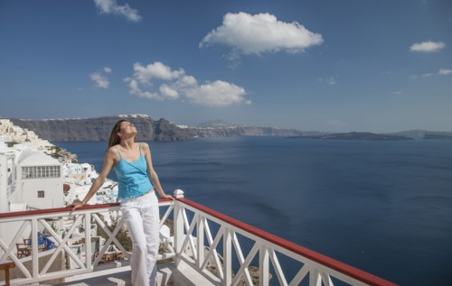Caucasian woman leaning on balcony railing overlooking ocean