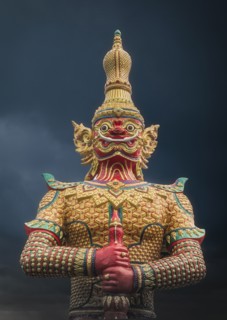 Ornate demon statue under cloudy sky