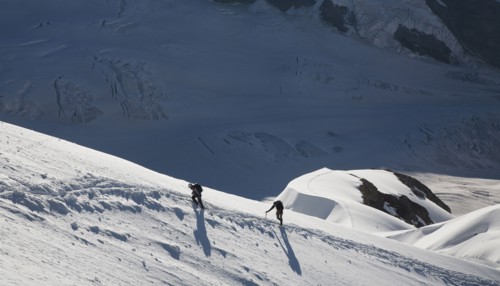 Caucasian men hiking on mountain in winter