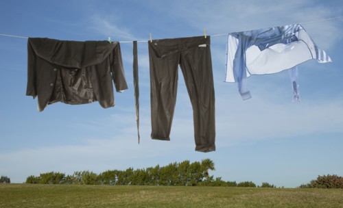 Wet business suit hanging on clothesline in field