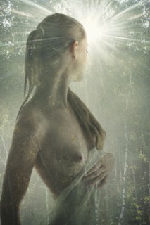 Double exposure of naked Caucasian woman in forest trees
