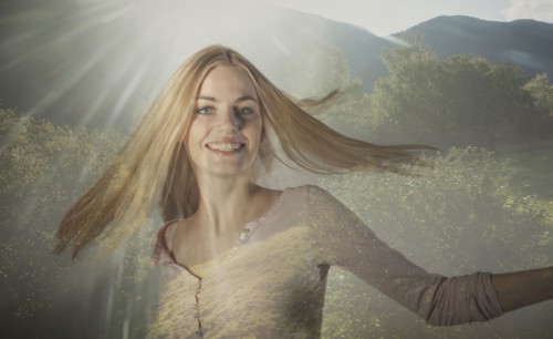 Double exposure of Caucasian woman spinning in forest trees