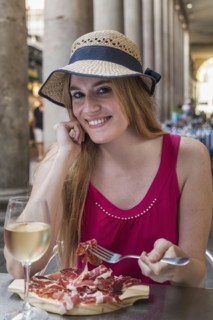 Portrait of smiling Caucasian woman eating meat at restaurant