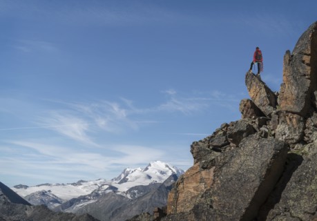 Distant Caucasian man standing on mountain rock